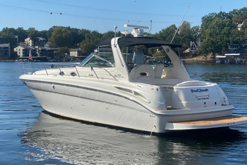 Slide: The Image of 1999 Sea Ray 380 Sundancer yacht on a serene lake with scenic background. - 6