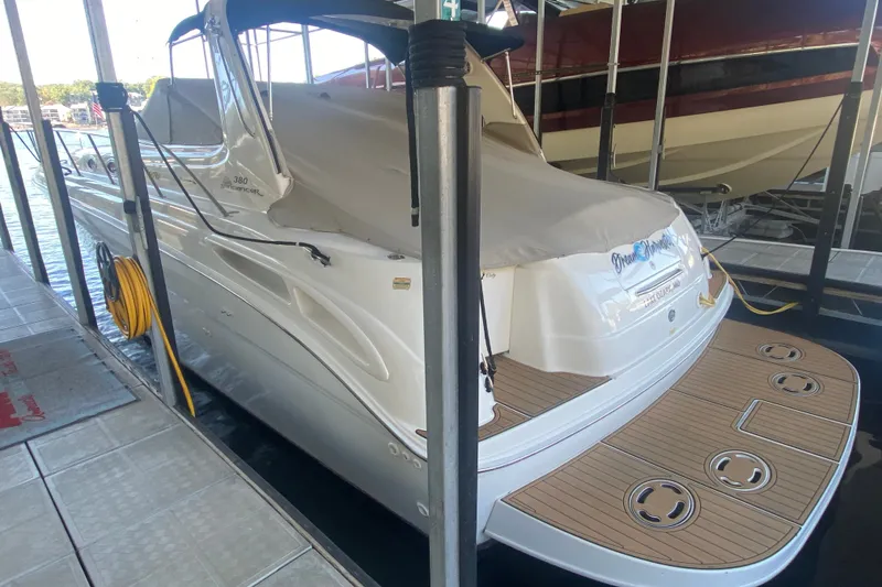 Slide: The Image of 1999 Sea Ray 380 Sundancer docked, featuring sleek design and spacious deck area. - 11