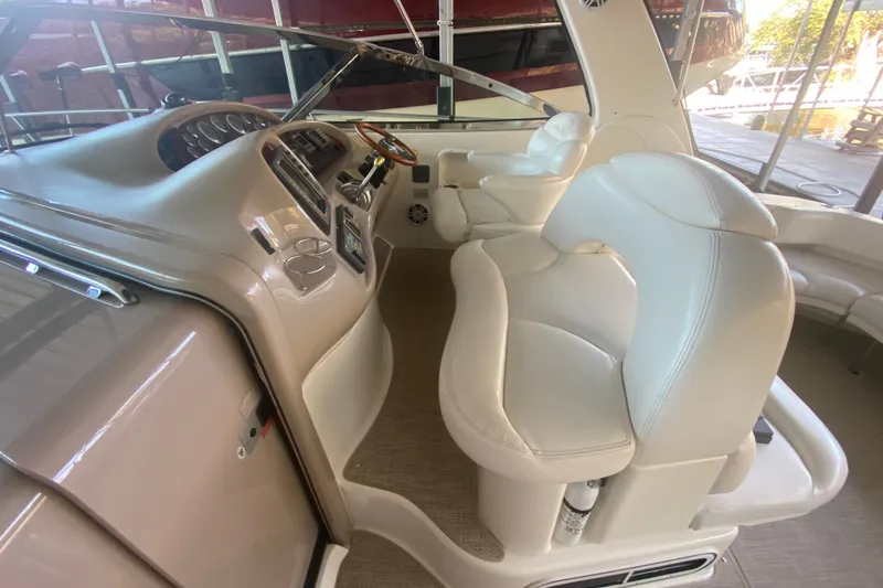 Slide: The Image of 1999 Sea Ray 380 Sundancer helm with white leather seating and control panel. - 15