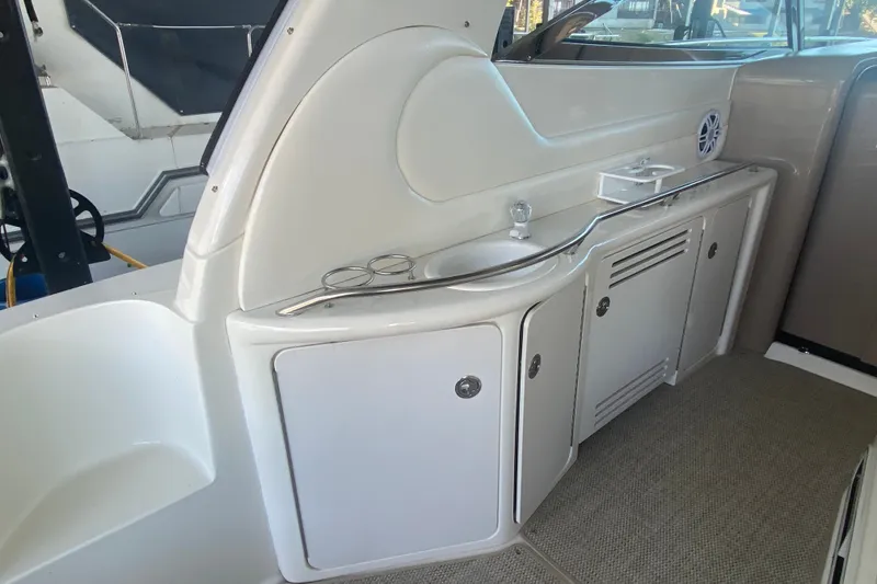 Slide: The Image of Interior view of a 1999 Sea Ray 380 Sundancer yacht, featuring a sleek kitchenette area. - 14