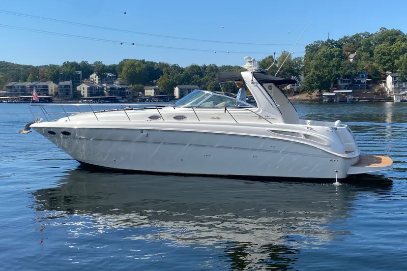 Slide: The Image of 1999 Sea Ray 380 Sundancer yacht on a serene lake with scenic background. - 3