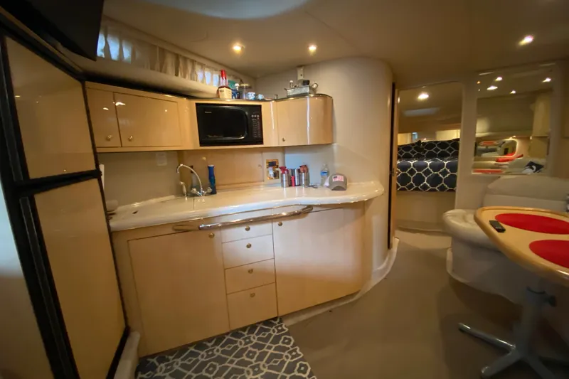 Slide: The Image of Interior of 1999 Sea Ray 380 Sundancer yacht with kitchenette and seating area. - 30