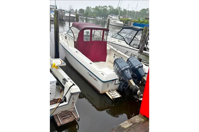 The Image of 2005 Cape Craft 2300 boat docked with dual outboard motors and maroon canopy. - 1