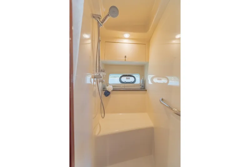 Slide: The Image of Luxurious shower area in 2015 Sea Ray 470 Sundancer yacht, featuring modern fixtures and porthole window. - 27