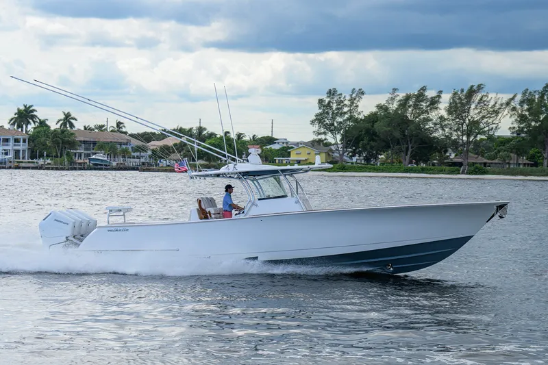 Slide: The Image of 2026 Valhalla V-41 boat cruising on a scenic waterway with lush greenery. - 12