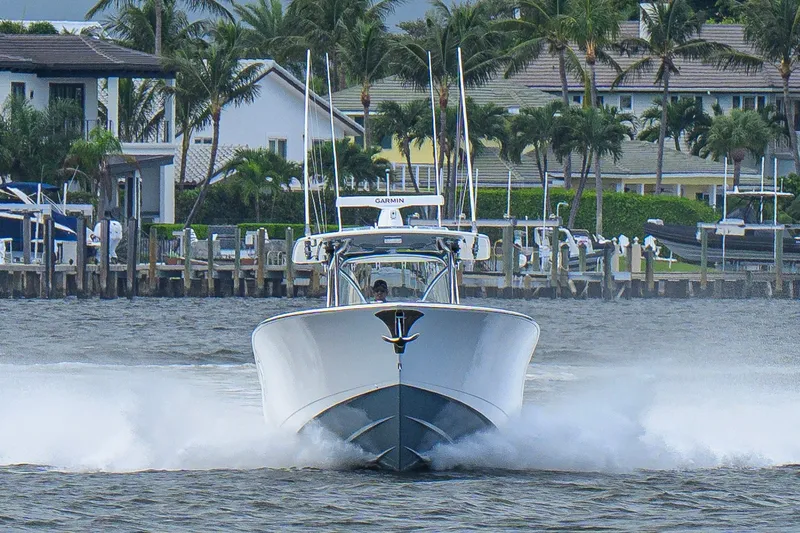 Slide: The Image of 2026 Valhalla V-41 boat cruising on water near a marina with palm trees. - 14