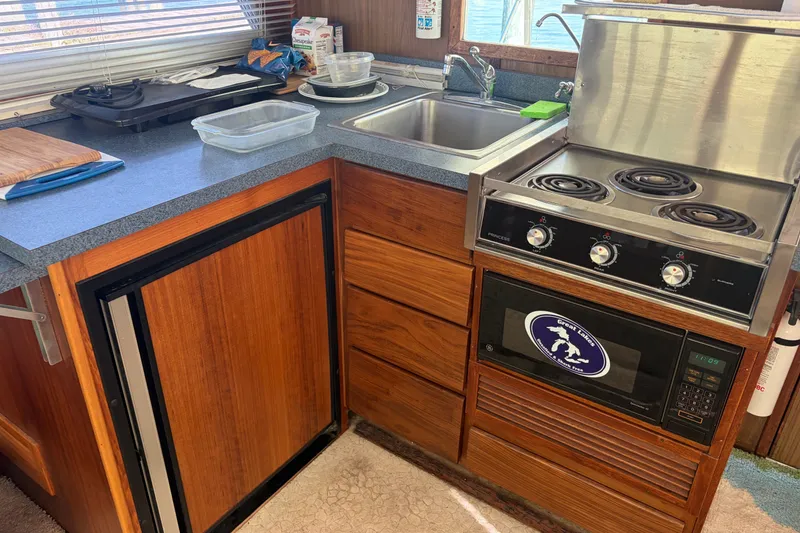 Slide: The Image of 1972 Hatteras 38 Convertible kitchen with stove, sink, and wooden cabinetry. - 34