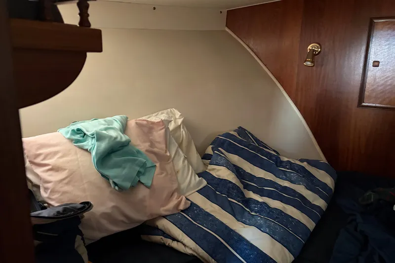 Slide: The Image of Cozy cabin interior of 1972 Hatteras 38 Convertible with striped bedding and wooden paneling. - 30