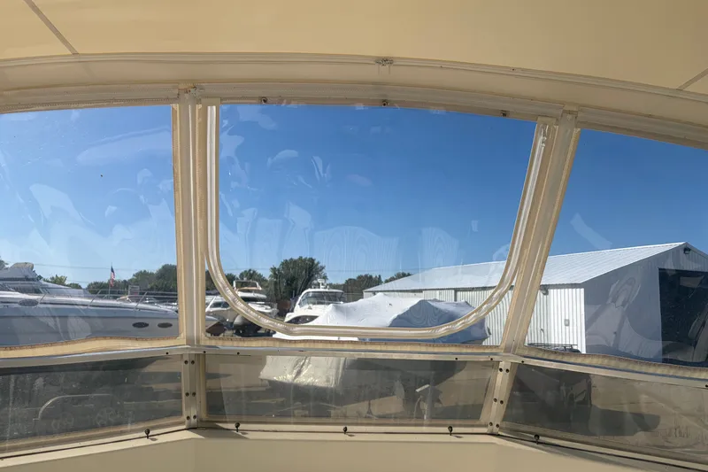 Slide: The Image of 1972 Hatteras 38 Convertible boat interior view with clear windows and marina backdrop. - 13