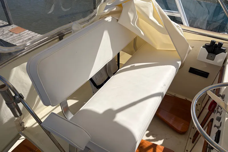 Slide: The Image of Interior of a 1972 Hatteras 38 Convertible boat with white seating and helm controls. - 17