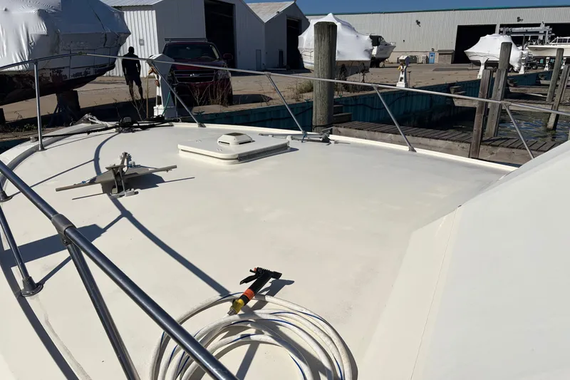 Slide: The Image of 1972 Hatteras 38 Convertible boat deck at a marina with stored vessels. - 33