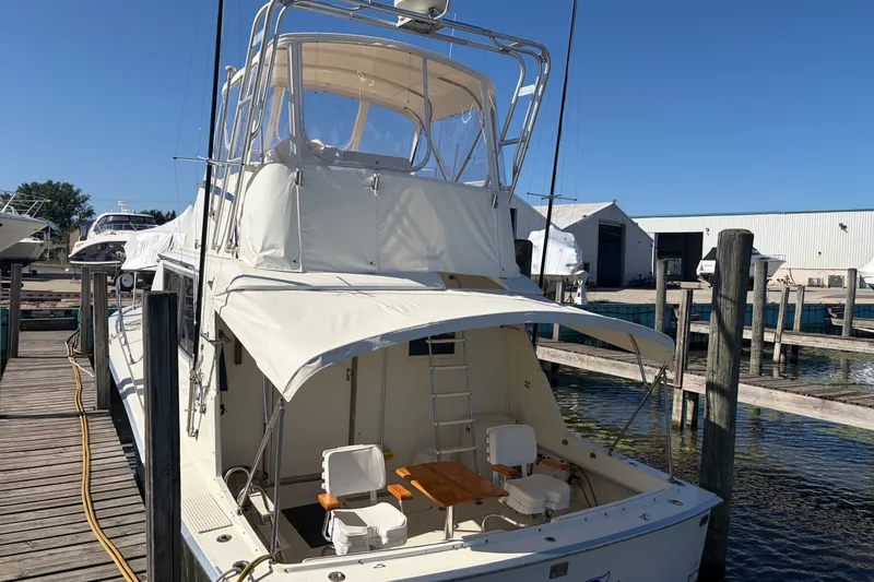 Slide: The Image of 1972 Hatteras 38 Convertible yacht docked at marina under clear blue sky. - 7