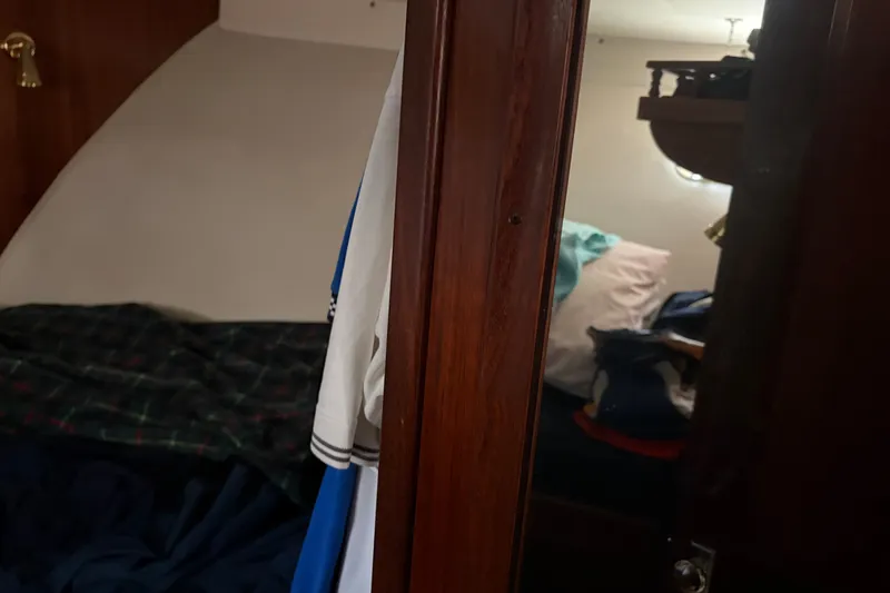 Slide: The Image of Interior cabin of a 1972 Hatteras 38 Convertible boat, featuring cozy bedding and wooden accents. - 32