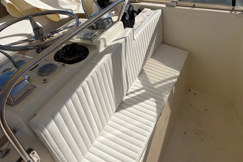 Slide: The Image of Interior of 1972 Hatteras 38 Convertible boat with white seating and steering wheel. - 14