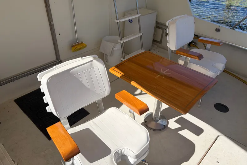 Slide: The Image of Interior of 1972 Hatteras 38 Convertible with white chairs and wooden table. - 4