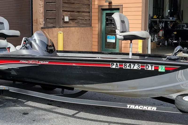 The Image of 2018 Tracker Pro Team 190 TX boat on trailer, parked outside a building. - 0
