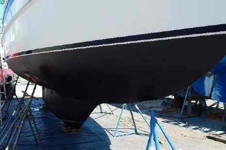Slide: The Image of 1995 Cabo Rico 34 sailboat hull on stands, undergoing maintenance. - 83