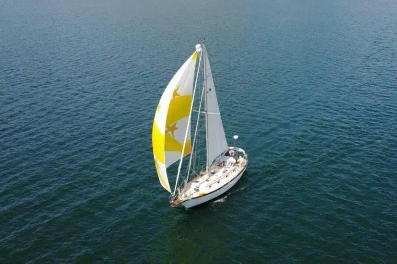 Slide: The Image of Sailing yacht Cabo Rico 34 (1995) with yellow and white sails on open water. - 2