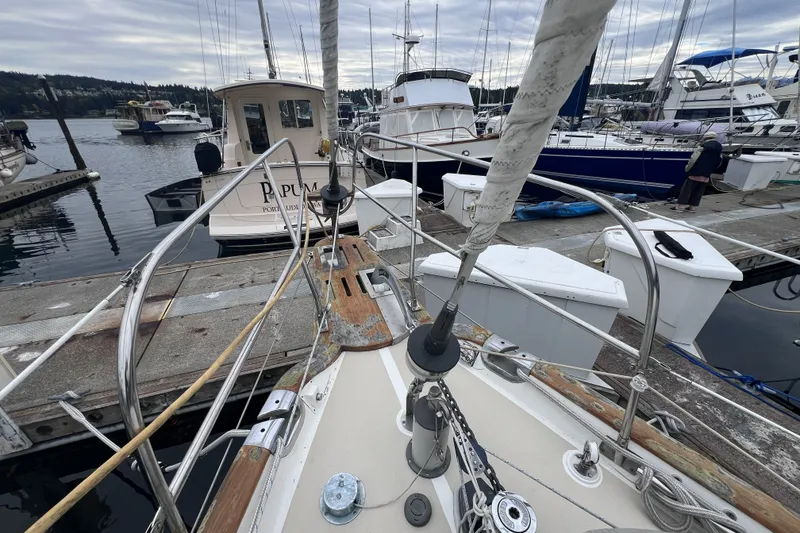 Slide: The Image of Sailboat Cabo Rico 34, 1995 model, docked at a marina with other boats. - 24