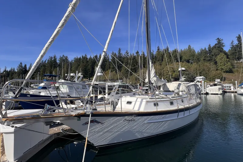 Slide: The Image of Sailboat docked in marina, Cabo Rico 34, 1995 model, surrounded by trees and clear sky. - 3