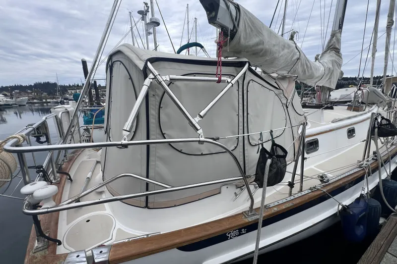 Slide: The Image of 1995 Cabo Rico 34 sailboat docked at marina, featuring covered cockpit and rigging. - 16