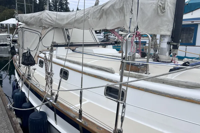 Slide: The Image of Sailboat Cabo Rico 34, 1995 model, docked at marina with covered sails. - 13