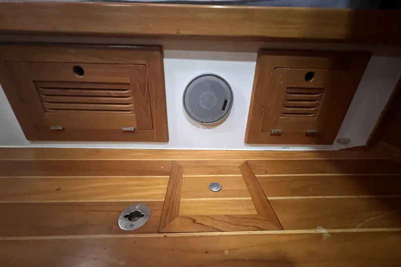 Slide: The Image of Wooden interior of a 1995 Cabo Rico 34 sailboat with speaker and storage compartments. - 59