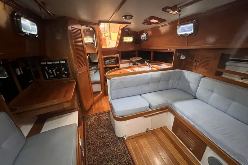 Slide: The Image of Interior of a 1995 Cabo Rico 34 sailboat with cozy seating and wooden finishes. - 53
