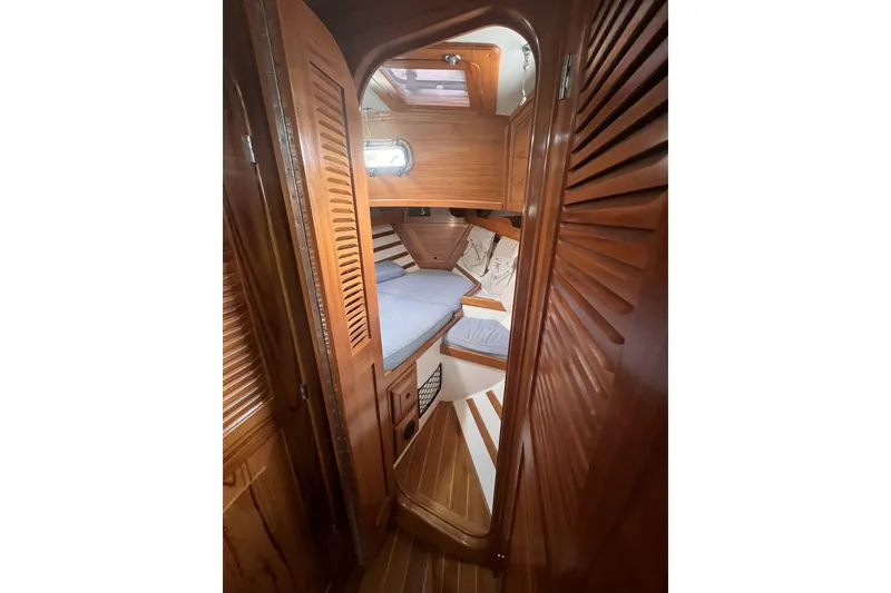 Slide: The Image of Interior view of 1995 Cabo Rico 34 sailboat cabin with wooden finish and cozy bedding. - 65