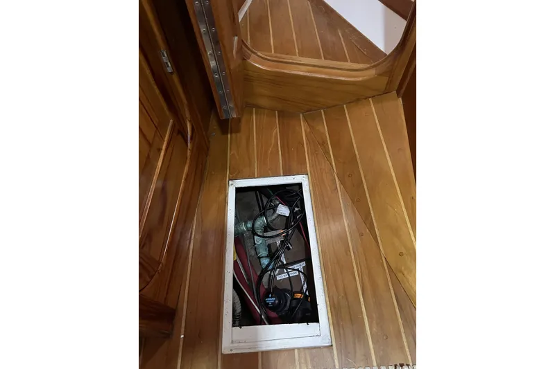 Slide: The Image of Wooden floor with open hatch revealing wiring on a 1995 Cabo Rico 34 sailboat. - 79