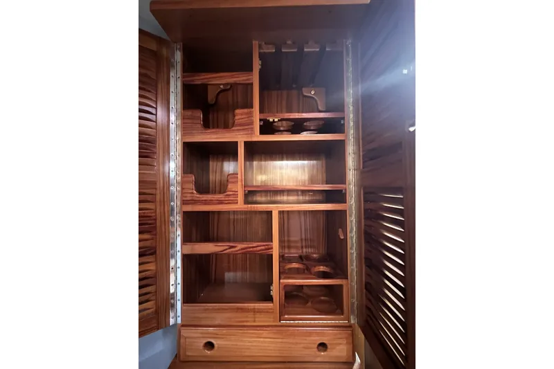 Slide: The Image of Wooden interior shelving of a 1995 Cabo Rico 34 yacht, featuring organized compartments. - 58