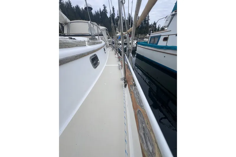 Slide: The Image of 1995 Cabo Rico 34 sailboat docked, showcasing deck and railing details. - 20