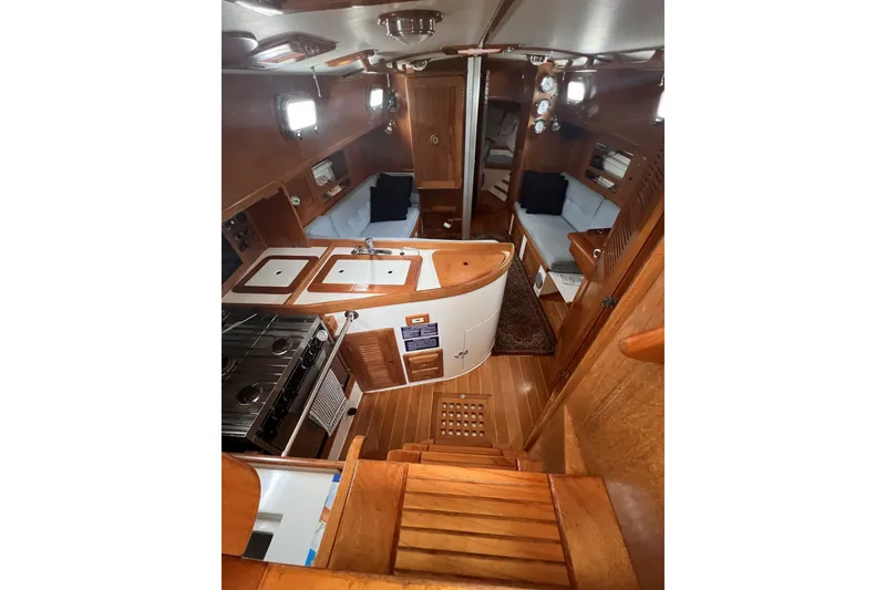Slide: The Image of Interior of a 1995 Cabo Rico 34 sailboat, featuring a cozy wooden cabin layout. - 37