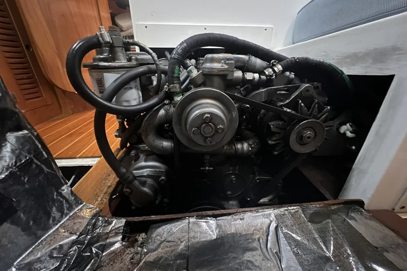 Slide: The Image of Engine compartment of a 1995 Cabo Rico 34 sailboat, showcasing mechanical components and hoses. - 73
