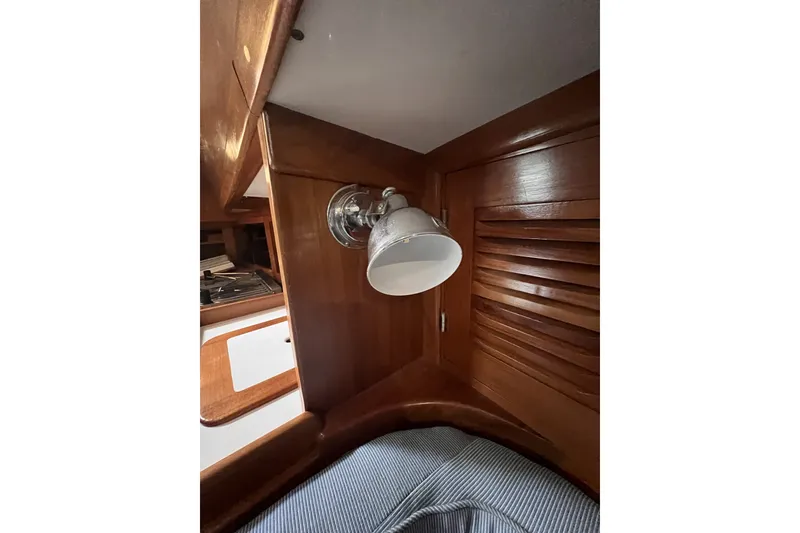 Slide: The Image of Interior of 1995 Cabo Rico 34 yacht featuring wooden cabinetry and a mounted light fixture. - 60