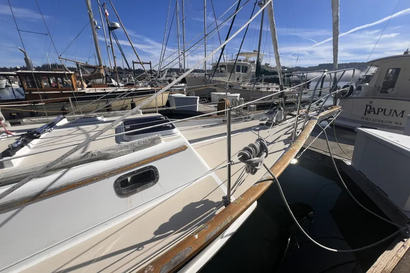 Slide: The Image of 1995 Cabo Rico 34 sailboat docked at a marina under clear blue skies. - 10