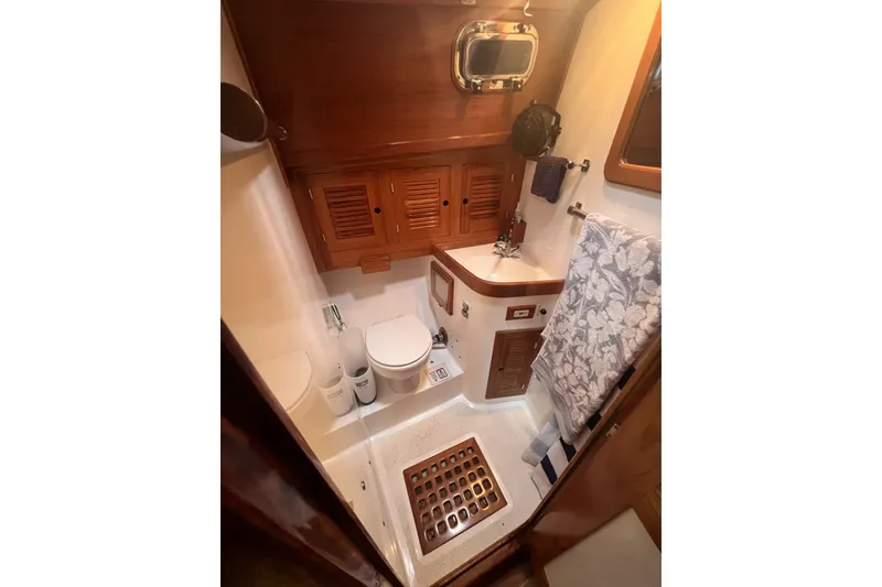 Slide: The Image of Cabo Rico 34 yacht bathroom, 1995 model, featuring wooden cabinetry and nautical decor. - 64