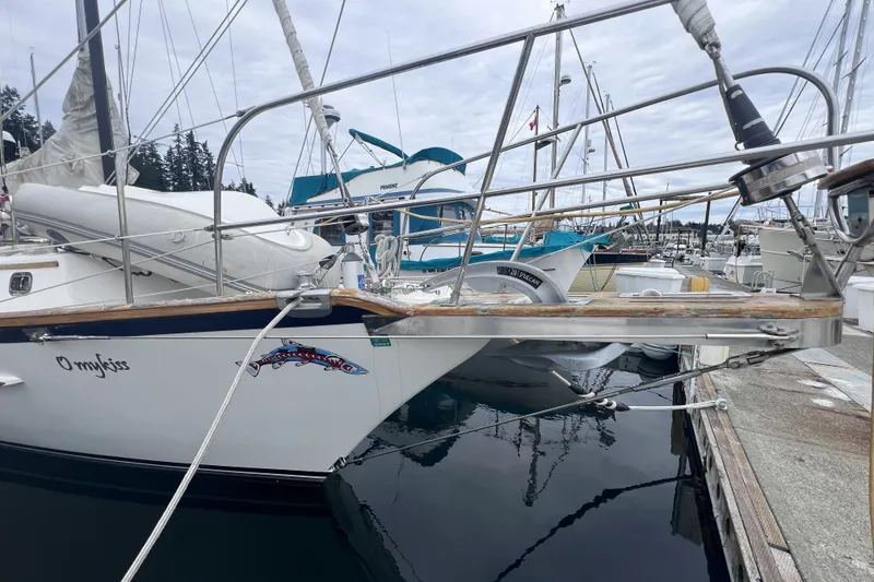 Slide: The Image of Cabo Rico 34 sailboat from 1995 docked at a marina, featuring a decorative fish graphic. - 5