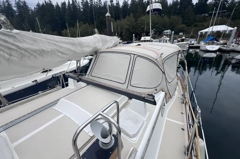 Slide: The Image of Sailboat Cabo Rico 34, 1995 model, docked in a marina with forest backdrop. - 22