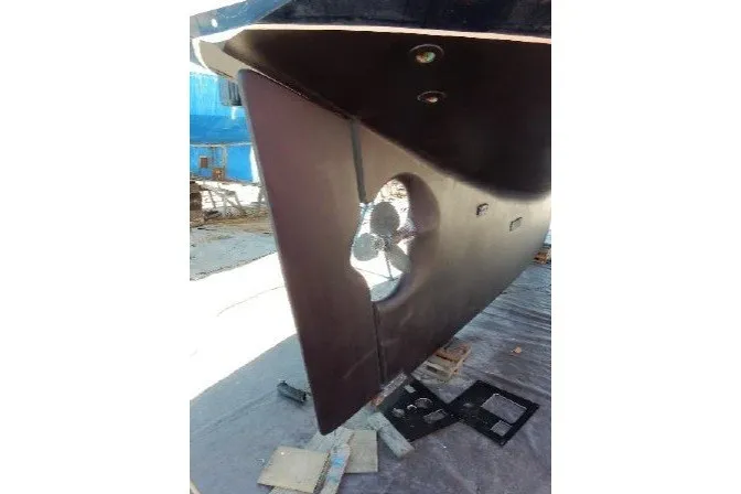 Slide: The Image of Cabo Rico 34 (1995) sailboat hull with visible propeller and rudder in dry dock. - 82