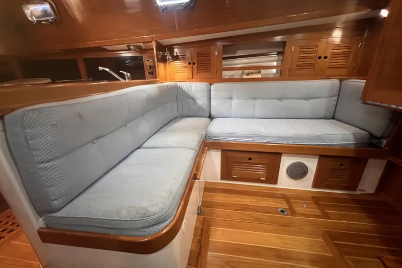 Slide: The Image of Interior of 1995 Cabo Rico 34 sailboat with wooden cabinetry and blue cushioned seating. - 55