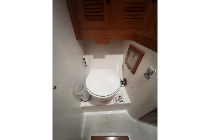 Slide: The Image of 1995 Cabo Rico 34 yacht bathroom with toilet and wooden cabinetry. - 63