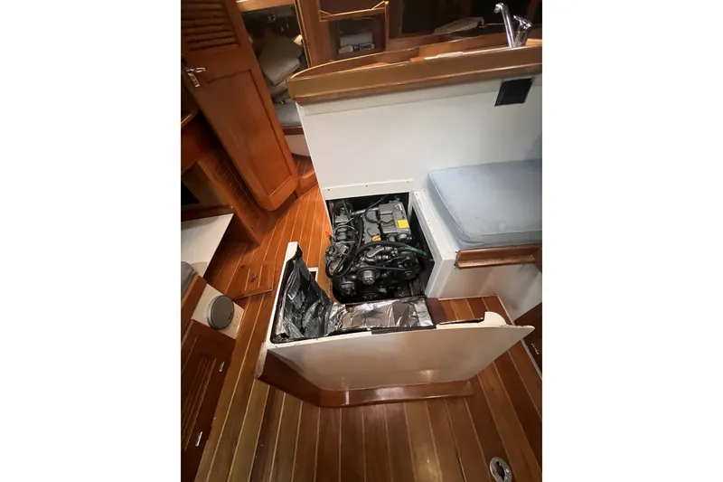 Slide: The Image of Engine compartment of a 1995 Cabo Rico 34 sailboat, showcasing wooden interior and seating. - 69
