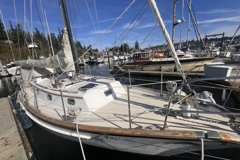 Slide: The Image of Sailboat Cabo Rico 34, 1995 model, docked at a marina under clear blue skies. - 4
