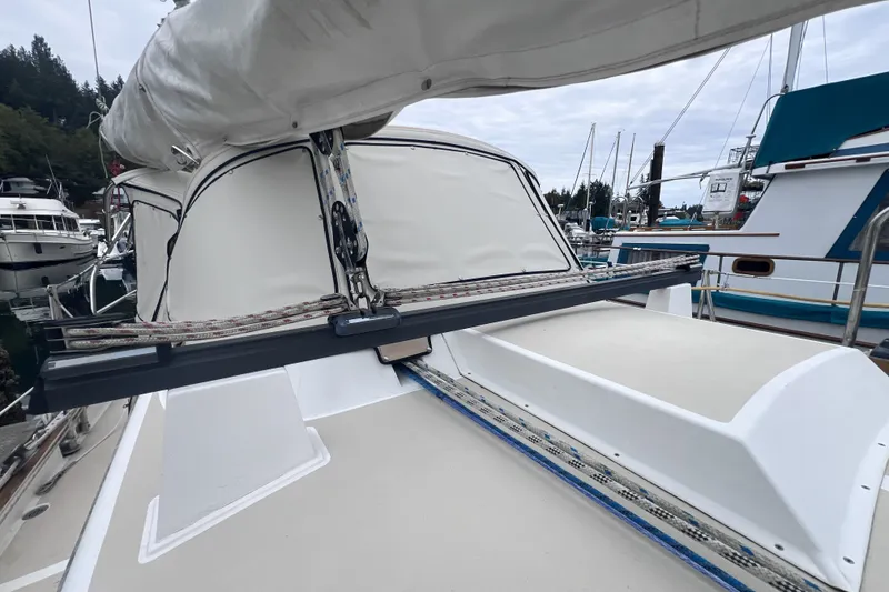 Slide: The Image of Sailboat deck of 1995 Cabo Rico 34, featuring rigging and sail cover in marina. - 17