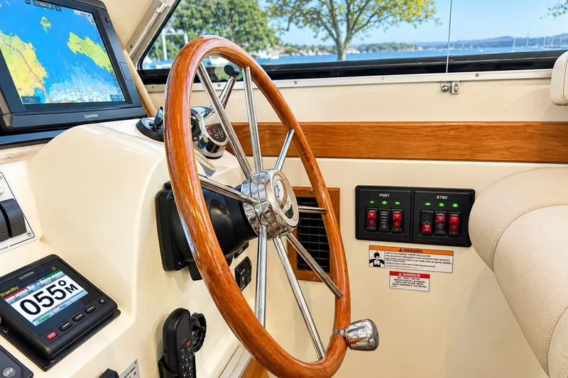 Slide: The Image of 2011 Back Cove 37 helm with wooden steering wheel and navigation equipment. - 16