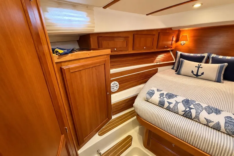 Slide: The Image of 2011 Back Cove 37 yacht cabin with wooden interior and nautical-themed bedding. - 28