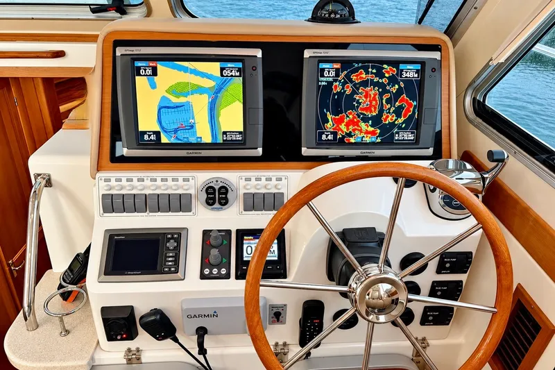 Slide: The Image of Helm of 2011 Back Cove 37 boat with Garmin navigation displays and wooden steering wheel. - 15