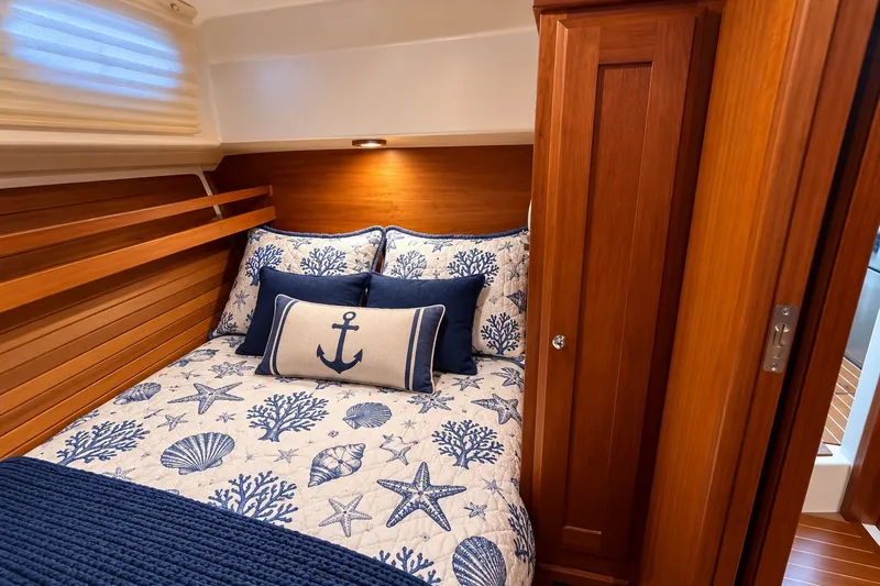 Slide: The Image of Cozy cabin interior of 2011 Back Cove 37 with nautical-themed bedding and wooden accents. - 31