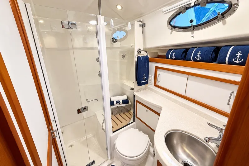Slide: The Image of Luxurious 2011 Back Cove 37 yacht bathroom with shower, sink, and nautical-themed decor. - 30